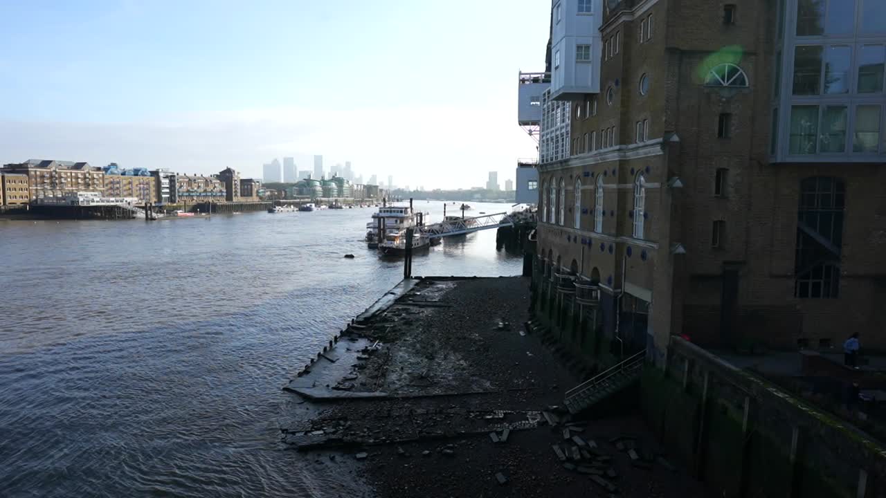Low tide on the Thames River at Horselydown Old Stairs with Canary Wharf skyline in the distance
