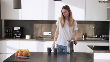 Una-Mujer-Joven-Vierte-Té-En-Tazas-De-Una-Tetera