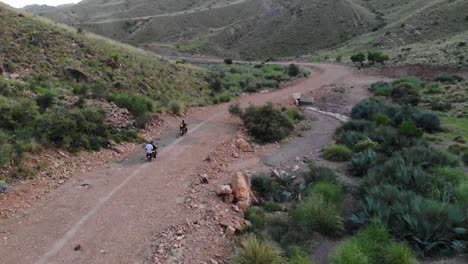 Toma-Aérea-De-Un-Grupo-De-Personas-Que-Viajan-En-Motocicleta-En-La-árida-Región-De-Khuzdar-Baluchistán