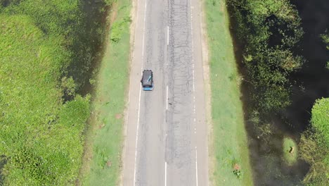 Rickshaw-Conduciendo-Por-Una-Carretera-Rodeada-De-Agua-En-Sri-Lanka