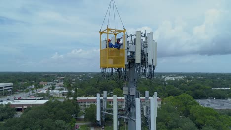 4K-Luftbildvideo-Des-Telekommunikationsturms,-Der-Von-Technikern-Gewartet-Wird