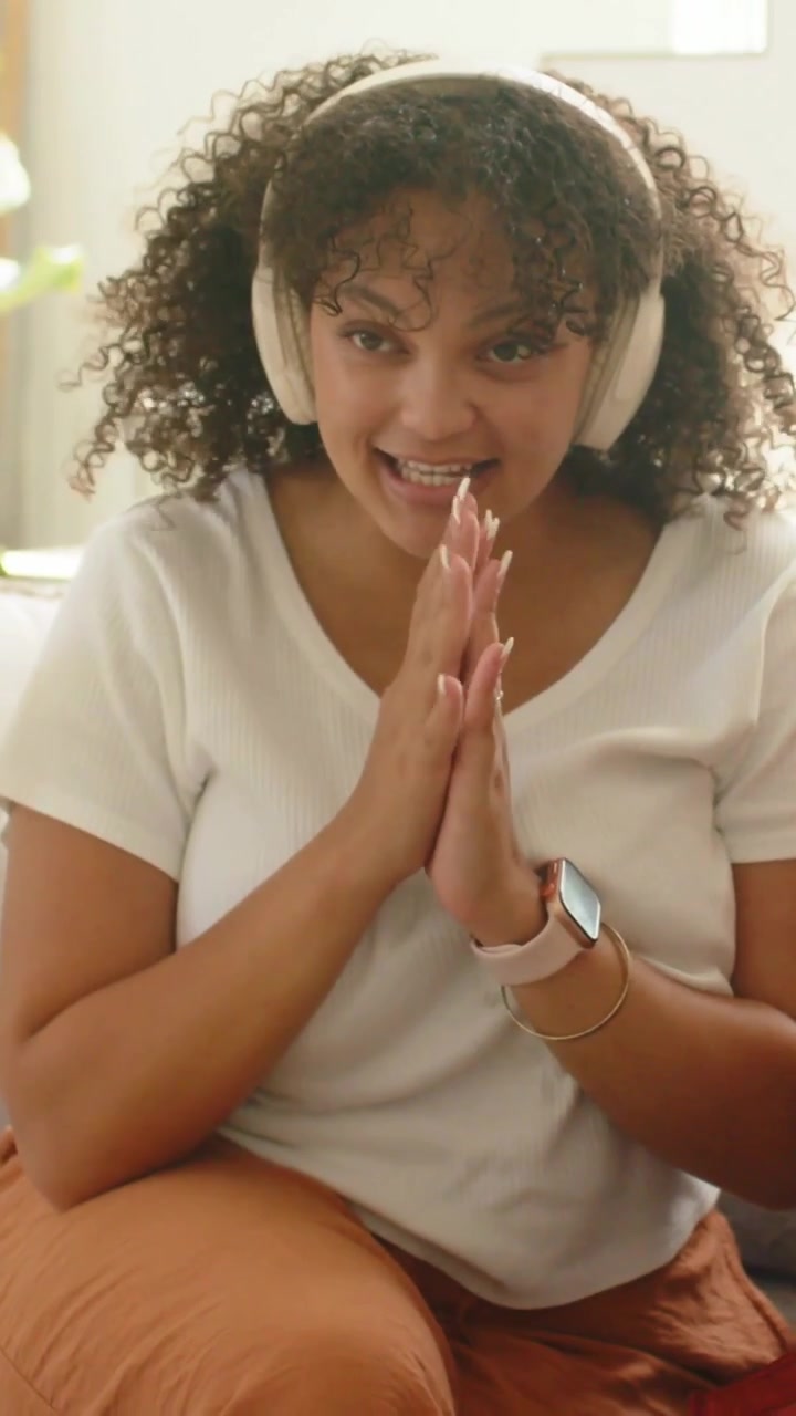 Vertical video: Camera starting, clapping woman with headphones reaching mic at home to fix sound