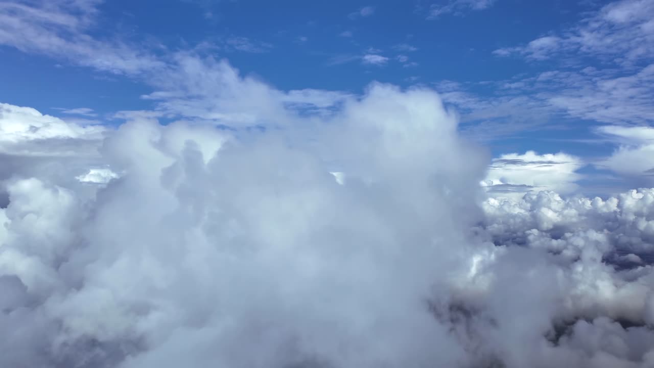 an immersive pilot’s perspective POV flying through cottony cumulus a stratocumulus clouds, under an intensde blue color sky. Ultra-realistic 4K