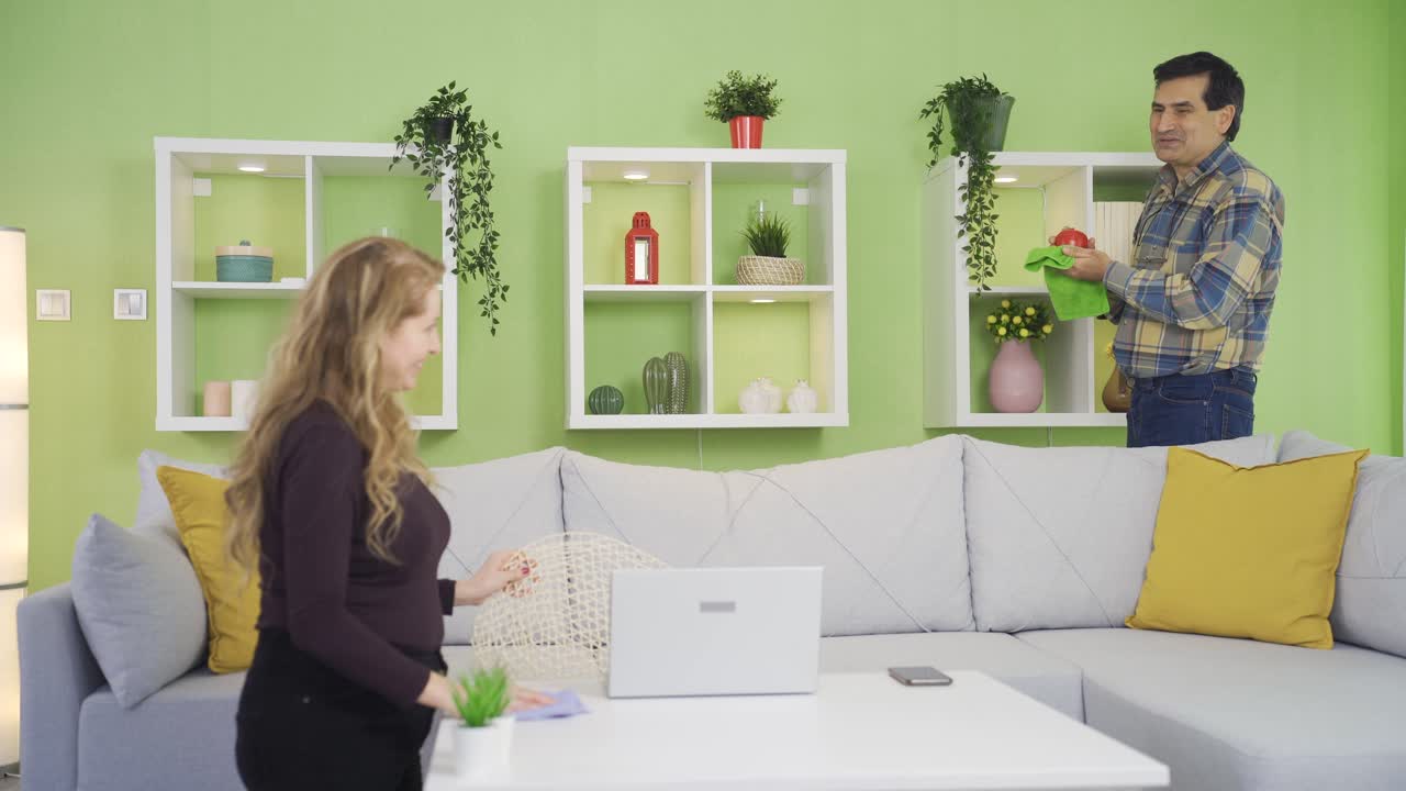 зрелый счастливый муж и жена делают веселую и приятную уборку дома вместе.