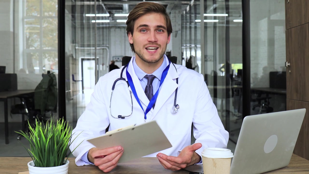 Giovane medico che parla alla telecamera durante un consulto online