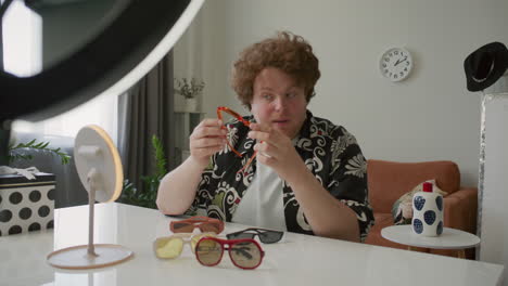 fashion blogger explaining how to wear sunglasses, filming vlog in home studio