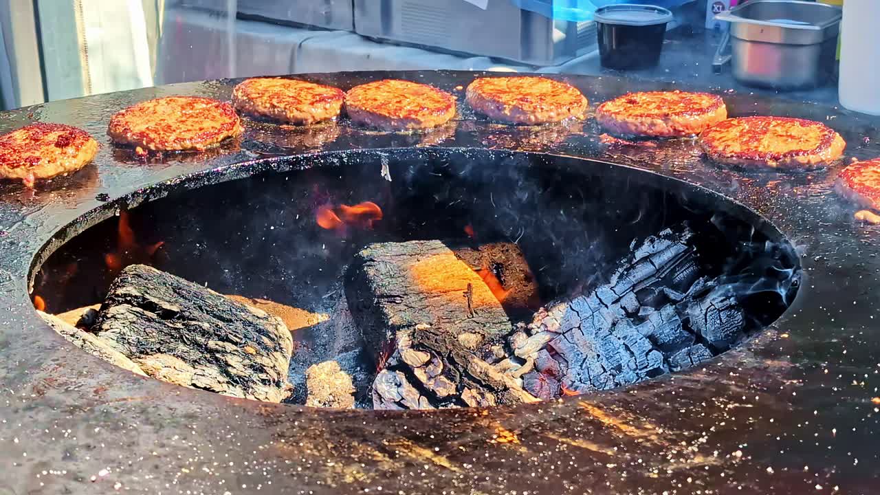 Beef burgers cooking over hot round open fire barbeque bbq festival comfort food