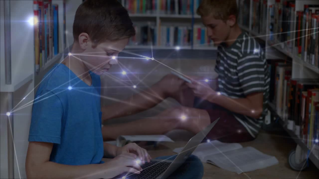 Two students in library typing on laptop, tapping tablet, causing drifting node overlay for study