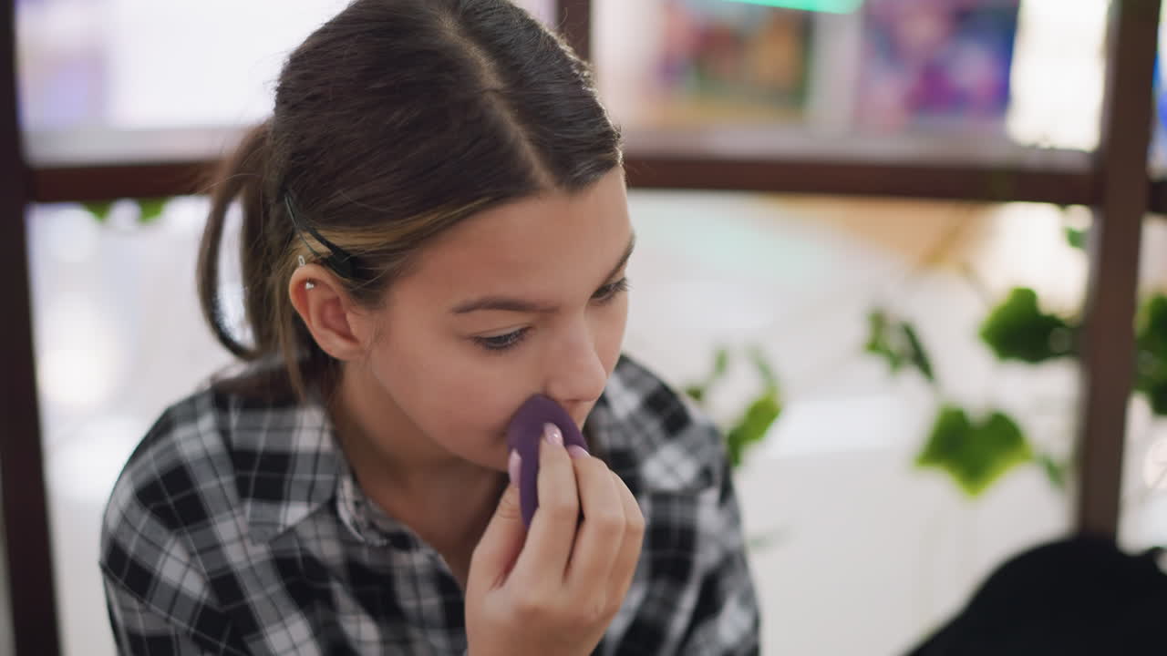 joven mezclando cuidadosamente maquillaje con esponja de belleza, centrándose en la aplicación precisa para una piel lisa y uniforme, entorno interior con iluminación suave destaca la rutina de belleza y el proceso de cuidado personal