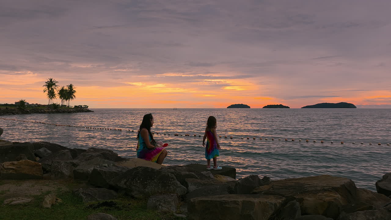 Mother And Daughter Bonding Moments On Rocky Waterfront Of Kota Kinabalu At Sunset In Sabah, Malaysia