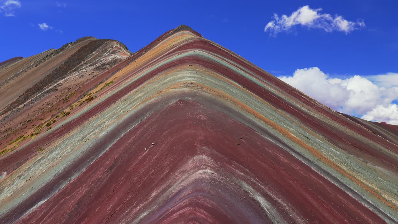 ペルーのビニクンカ、ペルーアンデス山脈のレインボーマウンテン。ビルカノタ山脈の風景、赤、オレンジ、黄褐色など7色の層が縞模様をなす丘の自然。晴れた朝の青空と雲が広がる南米の観光スポット。