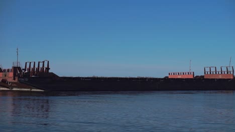 una gran barcaza oxidada en un río