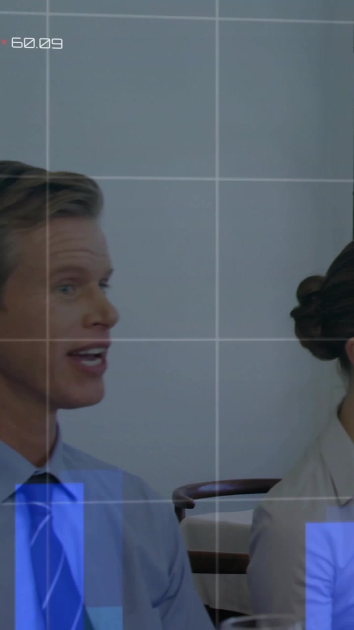 Video vertical: Hombre girándose para hablar con una mujer que come y usa el teléfono, con una superposición de datos empresariales sobre la mesa.