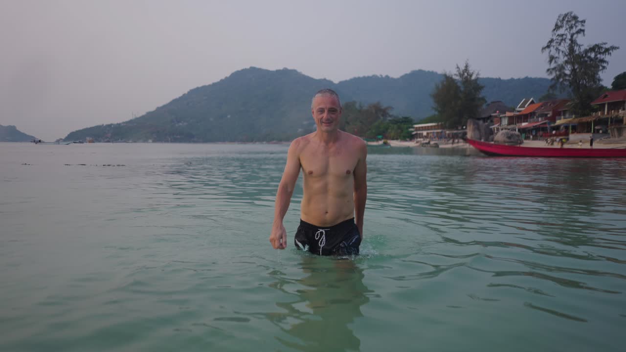 Man emerges from the water at a tropical beach