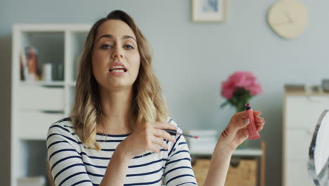 pretty beauty blogger recording a makeup tutorial video and talking about lipglosses