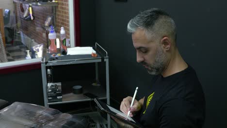 The-tattoo-artist-makes-an-initial-drawing-of-the-discussed-design-for-the-customer