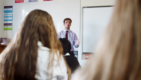 estudiantes adolescentes escuchando a un maestro masculino en el aula