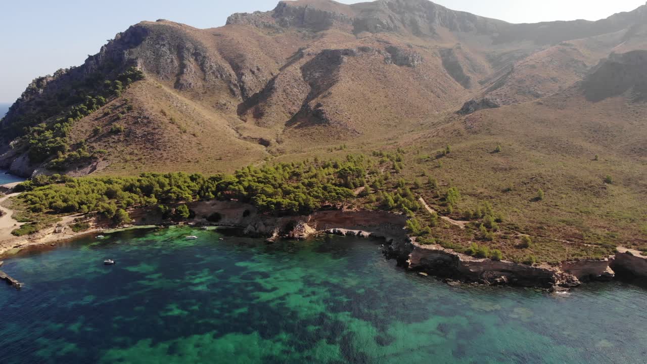 barcos anclados en una tranquila bahía frente a la escarpada costa norte de mallorca: antena