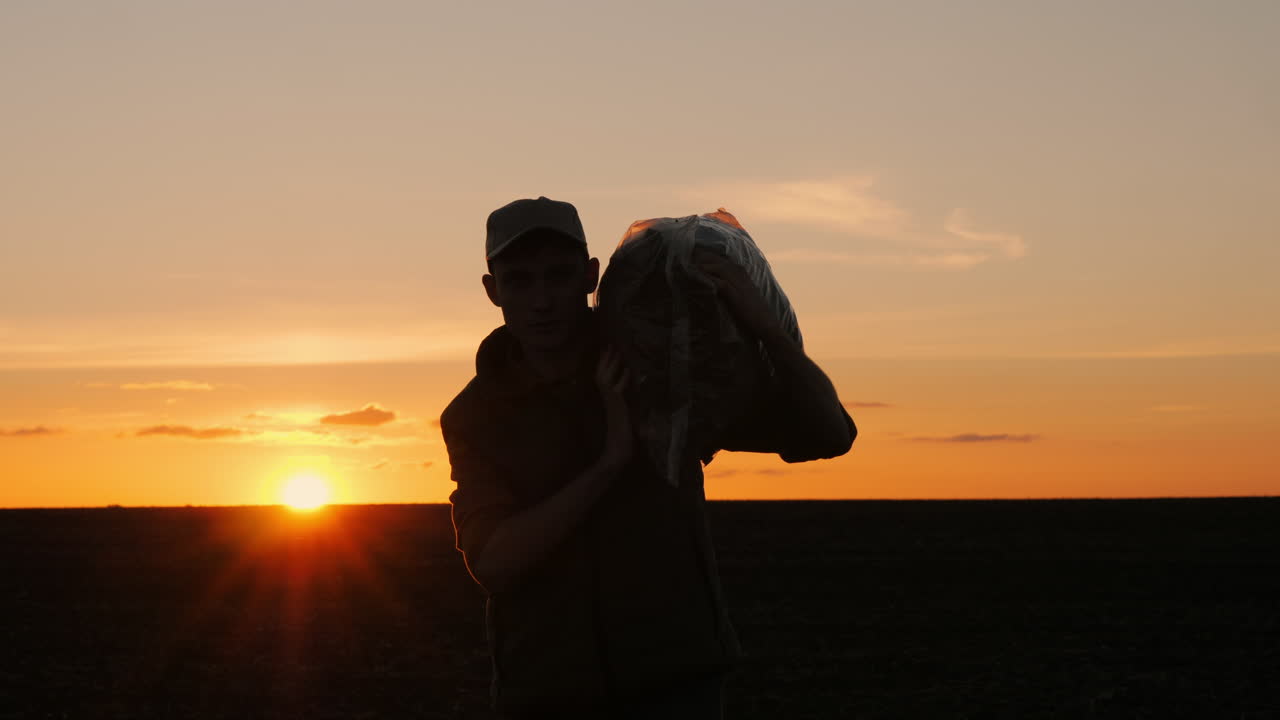 un granjero llevando una bolsa al atardecer