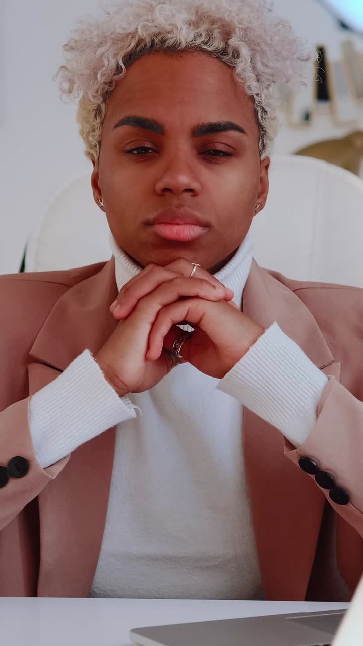 Young professional person with curly hair thoughtful and confident expression