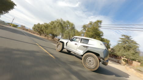 disparo de drone fpv de pick up negro conduciendo rápido en la carretera