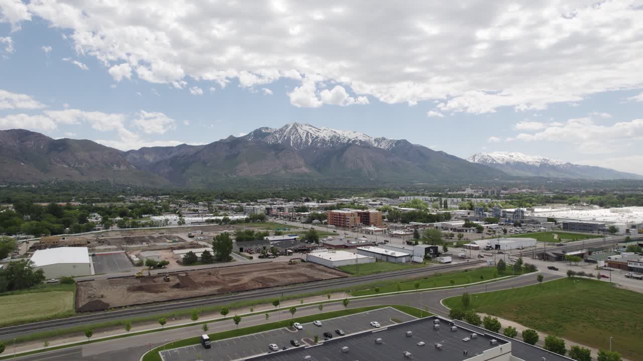 Aerial view of buildings and roads with snow-capped mountains in the background