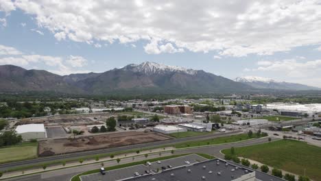 aerial view of buildings and roads with snow-capped mountains in the background