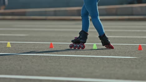 professional elements of criss-cross on roller skates. young woman dances on roller skates, goes round the cones. 4k, 10bit, prores