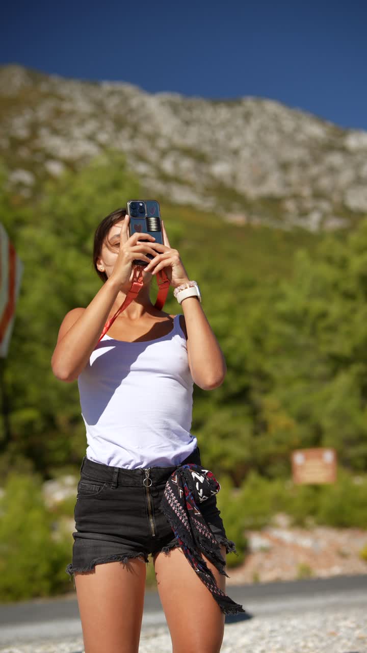 una adolescente tomando fotos al aire libre