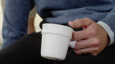 hombre de mediana edad sosteniendo una taza de café bebiendo de cerca tomar las manos manos espacio de oficina trabajador trabajo descanso almuerzo colegas discutiendo conversación conversando muñeca bebida caliente hablando hombres escuchando