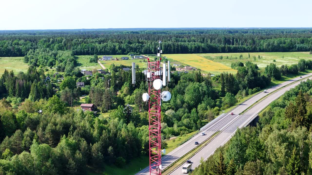 Cell tower GSM and 5G with forest and highway around, aerial orbit view