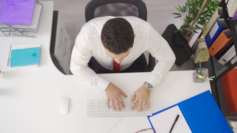 Investigative-businessman-working-in-office-focused-looking-at-his-computer.