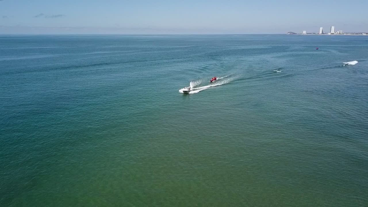 trineo de plátanos de agua recreativa rojo tirado por un bote a motor