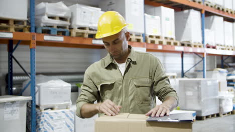 focused worker inspecting cardboard boxes, fixing helmet