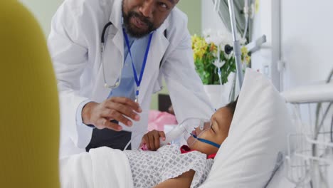 African-american-male-doctor-examining-child-patient-at-hospital