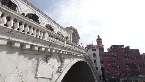 people at the famous rialto bridge on a sunny day in venice, italy