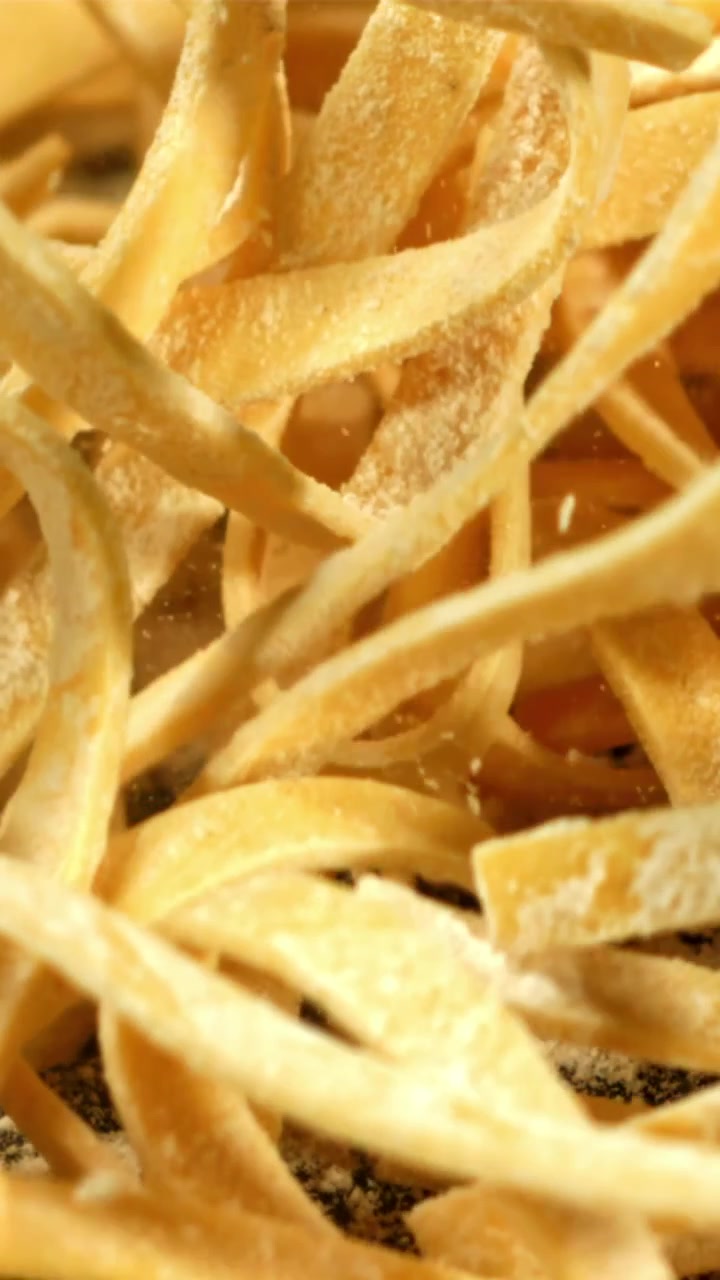 Primer Plano en Cámara Lenta de Pasta Fresca Cayendo sobre una Superficie Enharinada