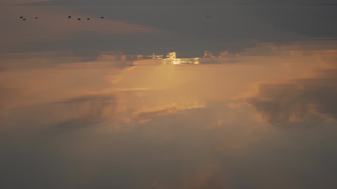 reflexión escénica de la puesta de sol de la hora dorada en el agua a cámara lenta