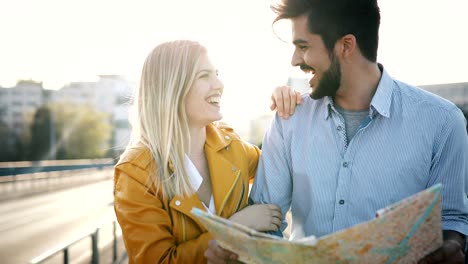 smiling couple in love traveling with a map outdoors