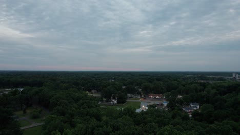 Un-Dron-Aéreo-Disparó-Sobre-Casas-En-El-Pequeño-Pueblo-Durante-La-Puesta-De-Sol-En-Una-Noche-Nublada