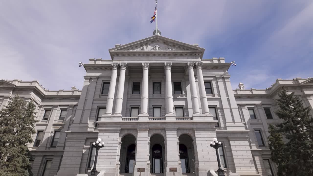 Colorado State Capitol Exterior Facade With Grand Columns And Flags Atop. low angle, tilt-up shot