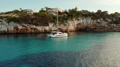 Katamaran-Boot-Segeln-Am-Strand-Von-Cala-Llombards-Auf-Mallorca,-Spanien