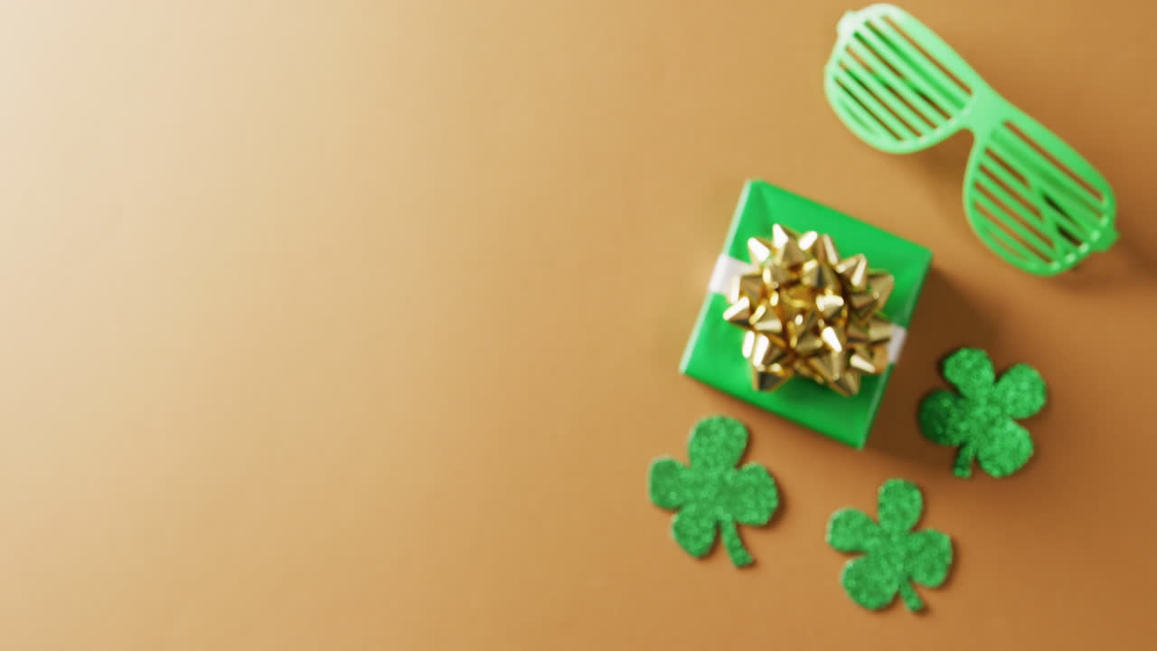 Video di trifoglio verde, regalo e occhiali per il giorno di San Patrizio con spazio per il testo su sfondo arancione