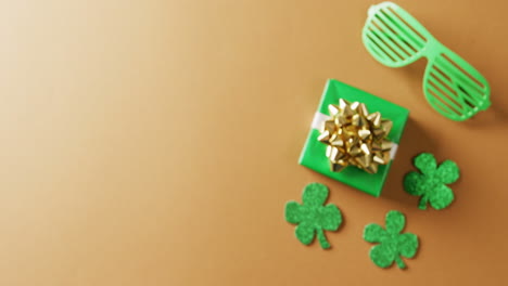 video del día de san patricio trébol verde, regalo y gafas con espacio de copia sobre fondo naranja