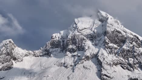 Langsam-Schwenkbare-Aufnahme,-Die-Im-Winter-Dicken-Schnee-Auf-Einem-Felsigen-Berg-Zeigt