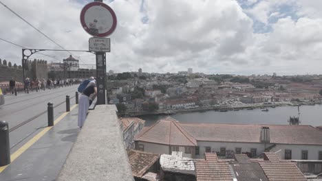 modern yellow tram crosses the dom luís i bridge in porto on a bright cloudy day