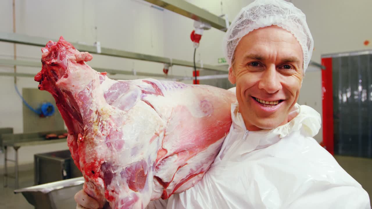 Smiling Butcher carrying meat