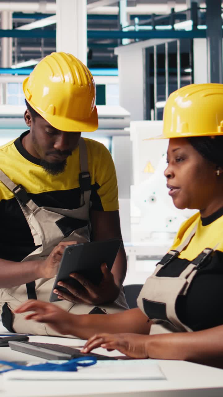 Vertical Video African american workers checking up on manufacturing equipment