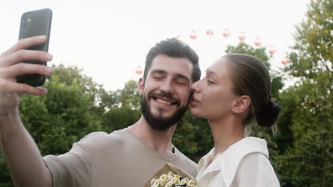 una pareja joven besándose en el parque.