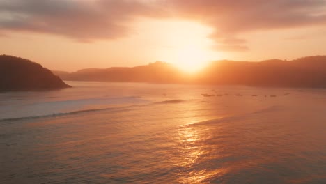 sunrise at the surf spots of gerupuk in lombok, with a view on the bay with the fishing boats and surfers